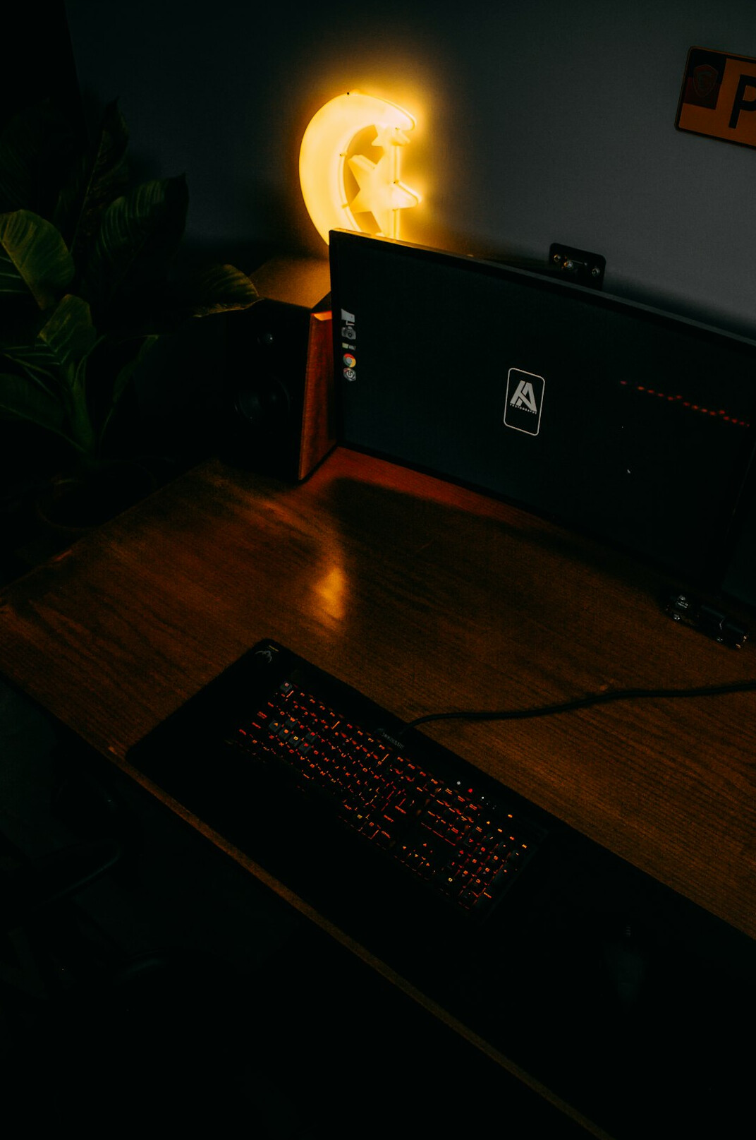Dark desk setup with keyboard and glowing monitor displaying code